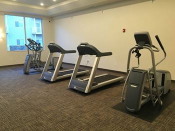a room with three treadmills and two elliptical machines at Latitude 46, North Dakota